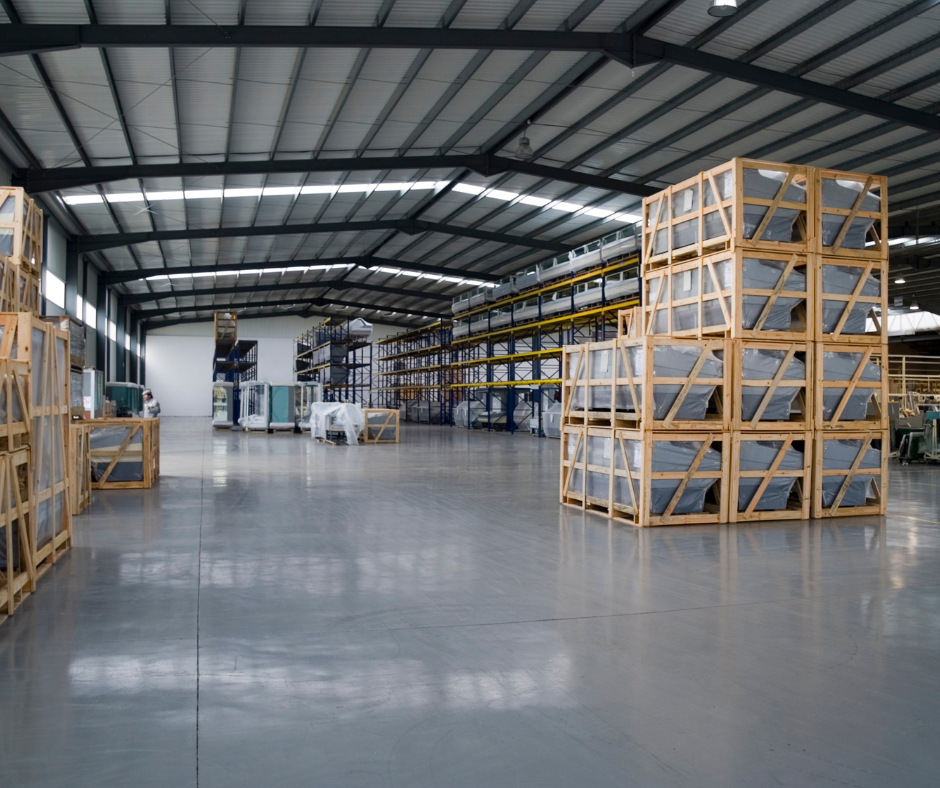Commercial restoration services in Jasper GA shown inside a restored warehouse with polished concrete floors, organized pallet storage, and structural steel framing